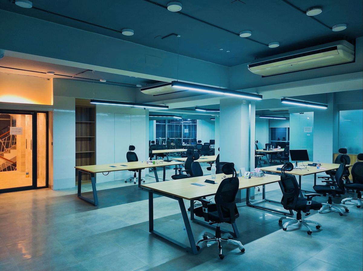 Rows of office desks and workstations in a modern open-plan office